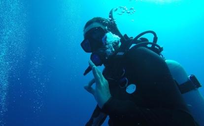 A volunteer in full scuba gear on a dive in Belize during his High School Special Conservation Project abroad. A volunteer uses sign language during a dive on the volunteering Conservation Project for high school students in Belize.